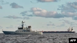 Kapal curah China, Yi Peng 3 (kanan), sedang berlabuh dan diawasi oleh kapal patroli di Laut Kattegat, dekat Kota Granaa di Jutland, Denmark, 20 November 2024. (Foto: Mikkel Berg Pedersen/Ritzau Scanpix via AFP)