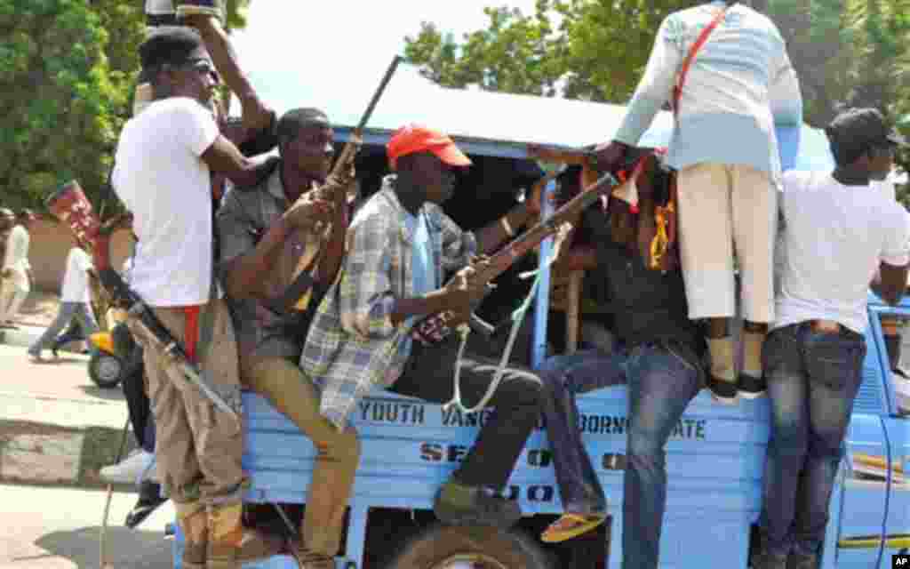 Un groupe d’auto-défense réuni avec des chasseurs locaux, armés de fusils, se rassemblent devant le palais de l'émir à Maiduguri, au Nigeria, le jeudi 4 septembre 2014. (AP Photo / Jossy Ola)