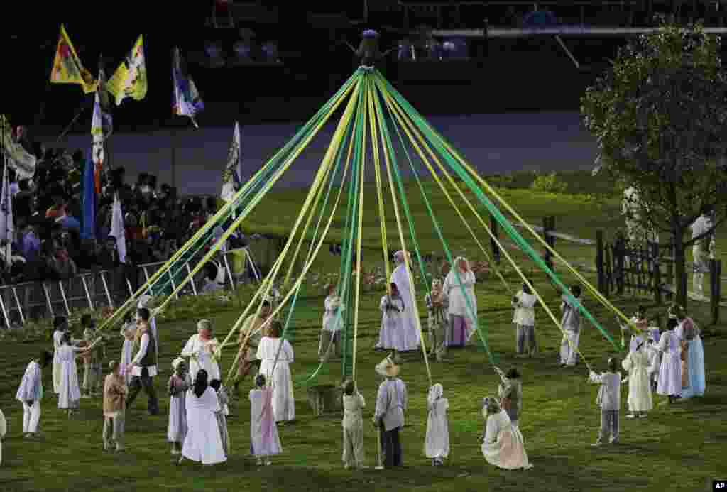Para aktor membuat formasi lingkaran dalam Upacara Pembukaan Olimpiade 2012 di London (27/7).