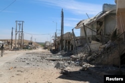 A man walks near damaged houses after Syrian rebels and the al-Qaida-affiliated Nusra Front took control of al-'Iss town, in Aleppo countryside, Syria, April 2, 2016.