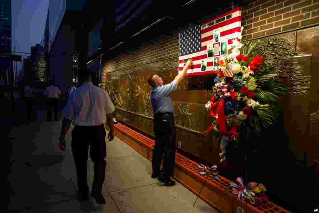 FDNY Firefighter Mike Bellantoni prepares a memento at the Firefighter's Memorial adjacent to the One World Trade Center, Sept. 11, 2013.