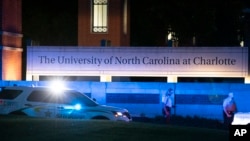 Police secure the main entrance to UNC Charlotte after a shooting at the school that left at least two people dead, April 30, 2019, in Charlotte, N.C.