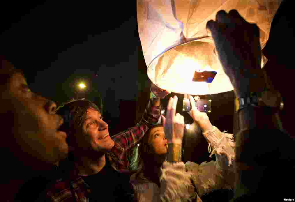 People release paper lanterns after lighting them outside Madiba, a restaurant named in honor of Nelson Mandela, in the Brooklyn borough of New York, Dec. 5, 2013.
