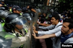 Opposition supporters confront riot security forces while rallying against President Nicolas Maduro in Caracas, Venezuela, May 12, 2017.