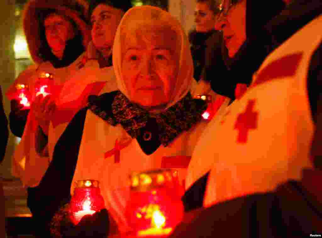 People hold candles as they mark the upcoming World AIDS Day in Kyiv, Ukraine, November 29, 2012.