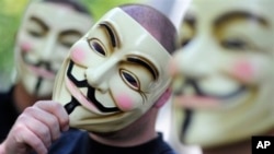 FILE - Activists of the international network "Anonymous" pose with Guy Fawkes masks in an undated photo in Berlin, Germany. The group has declared "total war" against US presidential hopeful Donald Trump.