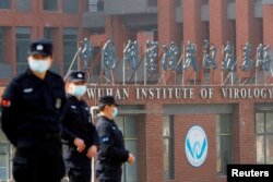 Petugas keamanan berjaga di luar Institut Virologi Wuhan selama kunjungan tim WHO yang bertugas menyelidiki asal-usul COVID-19, di Wuhan, Hubei, Tiongkok, 3 Februari 2021. (Foto: Reuters)