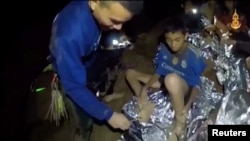 Boys from the under-16 soccer team trapped inside Tham Luang cave receive treatment from a medic in Chiang Rai, Thailand, in this still image taken from a July 3, 2018, video by Thai Navy Seal.