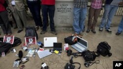 Members of the press stand by their working tools as they protest violence against journalists at the border by a sign that reads in Spanish "Limit of the Mexican Republic" in Tijuana, Mexico, 7 Aug 2010