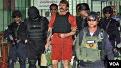 Tersangka penjual senjata Rusia, Victor Bout, meninggalkan pengadilan di Bangkok.