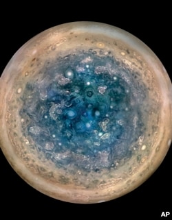 This image made available by NASA on May 25, 2017, and made from data captured by the Juno spacecraft shows Jupiter's south pole. The oval features are cyclones, up to 600 miles (1,000 kilometers) in diameter.
