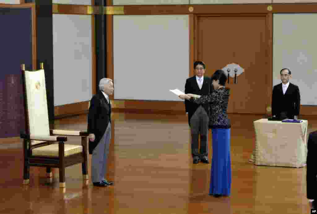Japanese Emperor Akihito (left) accompanied by Prime Minister Shinzo Abe (second left) stands as newly-appointed Trade and Economy Minister Yuko Obuchi, second right, receives a attestation certificate during a ceremony at the Imperial Palace, in Tokyo, Sept. 3, 2014.