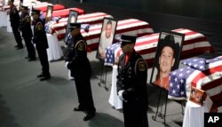 Honor guard stand in front of caskets prior to a memorial service for first responders who died in last week's fertilizer plant explosion in West, Texas, April 25, 2013.