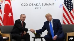 Presiden Donald Trump, kanan, berjabat tangan dengan Presiden Turki Recep Tayyip Erdogan selama pertemuan di sela-sela KTT G-20 di Osaka, Jepang, 29 Juni 2019. (Foto: AP)
