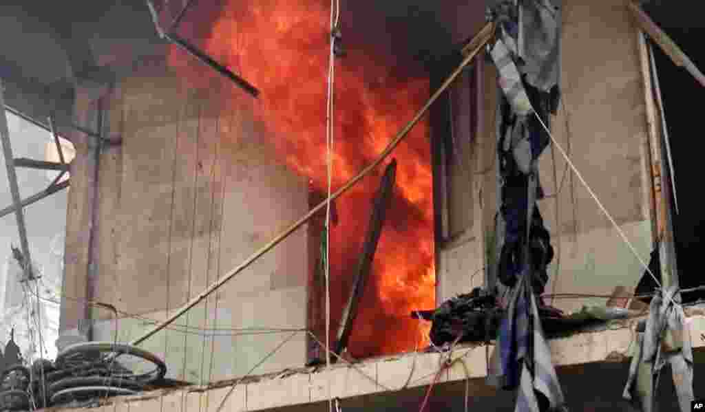 Bangunan terbakar oleh serangan udara di Aleppo (28/4).