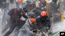Anti-government protesters take cover from a police water cannon during clashes in Madrid, on the outskirts of Bogota, Colombia, May 28, 2021. 
