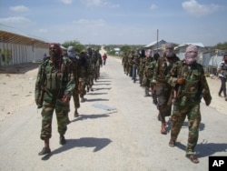 FILE - Members of Somalia's al- Shabab militant group patrol on foot on the outskirts of Mogadishu.