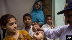 Petugas kesehatan memberikan vaksin polio kepada anak-anak di Pakistan (foto:dok).