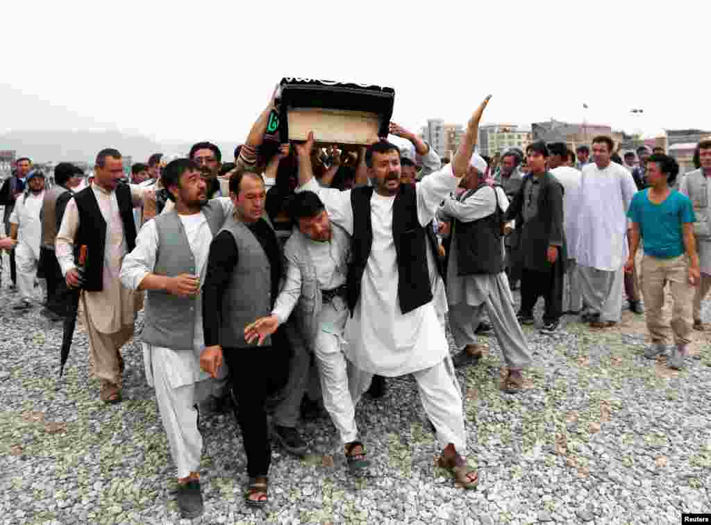 Men carry the coffin of a victim a day after a suicide attack in Kabul, Afghanistan.
