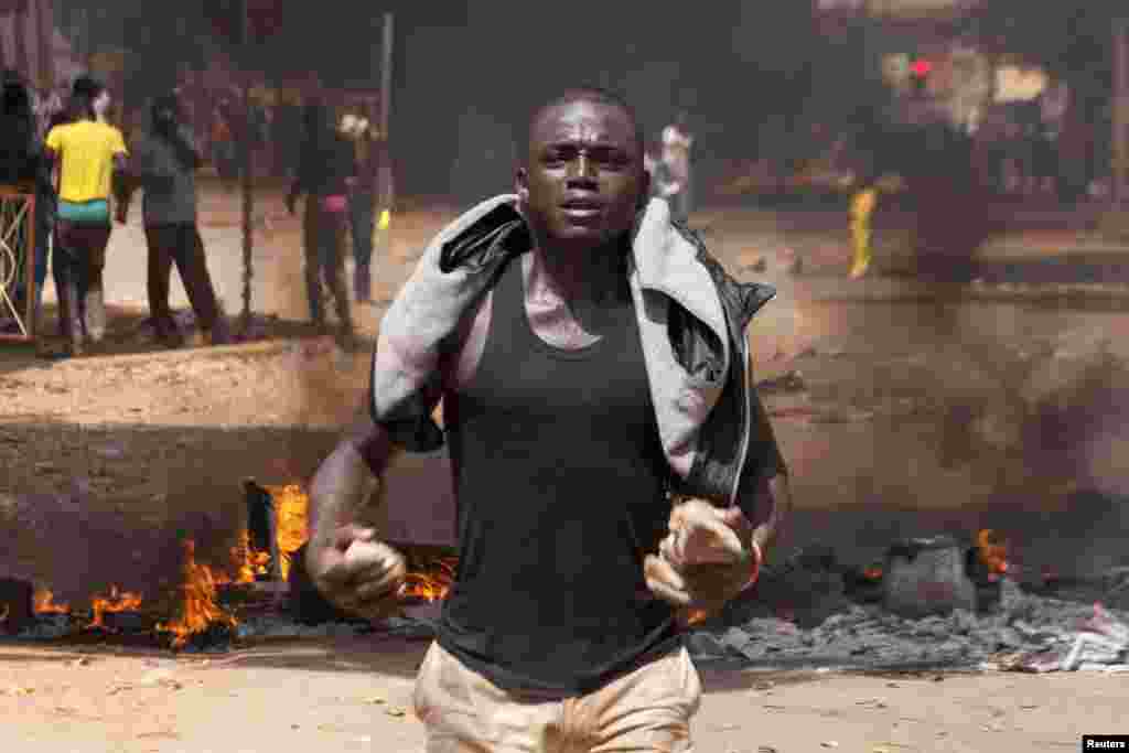 Un manifestant a des pierres dans ses mains sur une route barricadée à Ouagadougou, capitale de Burkina Faso, le 28 octobre 2014. REUTERS/Joe Penney