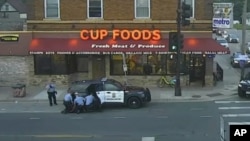 In this May 25, 2020, image from surveillance video, Minneapolis police officers, from left, Tou Thao, Derek Chauvin, J. Alexander Kueng and Thomas Lane are seen attempting to take George Floyd into custody in Minneapolis, Minnesota.