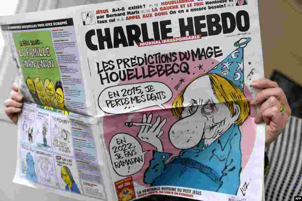 Une personne lit le dernier numéro du journal satirique français Charlie Hebdo après que des tireurs armés de kalachnikovs et de lance-roquettes ont ouvert le feu dans les bureaux de l'hebdomadaire, tuant au moins 12, à Paris, le 7 janvier 2015.
