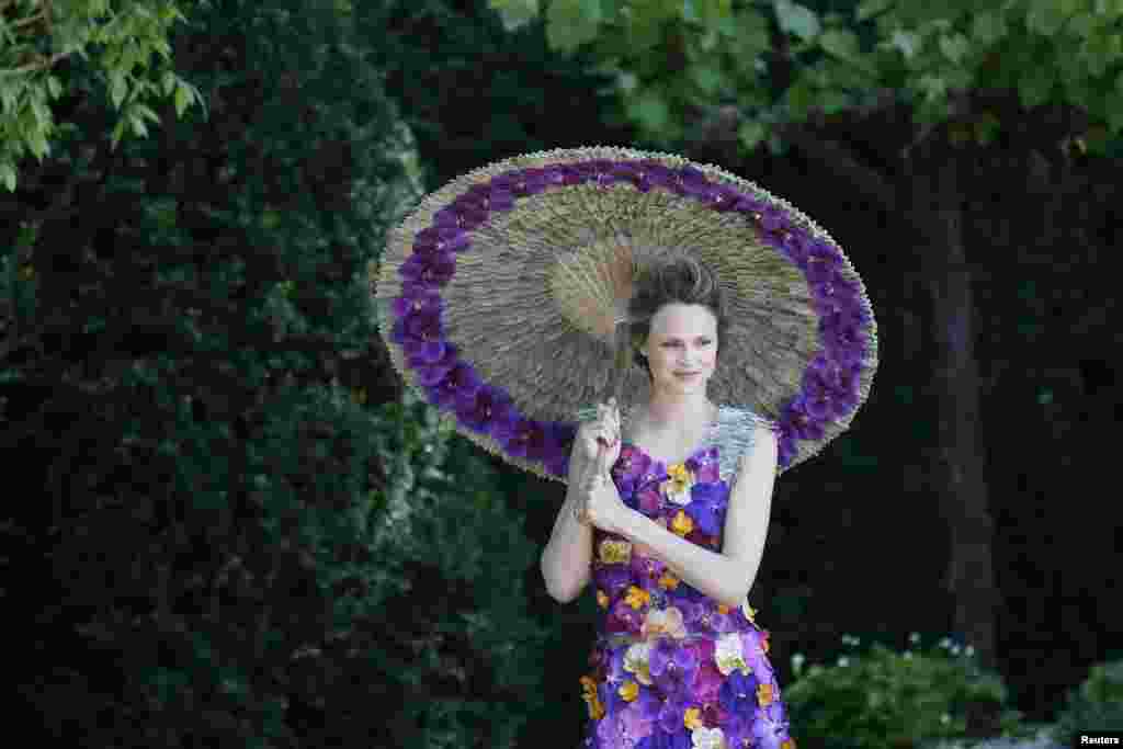 A model wearing a dress made of 1,000 Orchida Vanda petals, designed by Judith Blacklock, poses for photographers in the M & A Garden during media day at the Chelsea Flower Show in London.