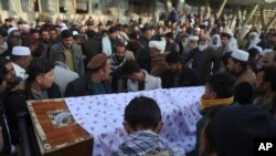FILE - Afghans carry the coffin of a victim of a bombing and shooting attack, during his funeral, in Kabul, Afghanistan, Dec. 23, 2020.