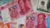 FILE - In this Aug. 6, 2019, photo, a man walks by a money exchange shop decorated with Chinese yuan bank notes and other countries' currency at Central, a business district in Hong Kong. 