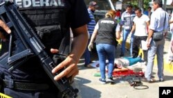 FILE - Police and forensics experts secure the area where six people were killed, in Acapulco, Mexico, Jan. 4, 2017.