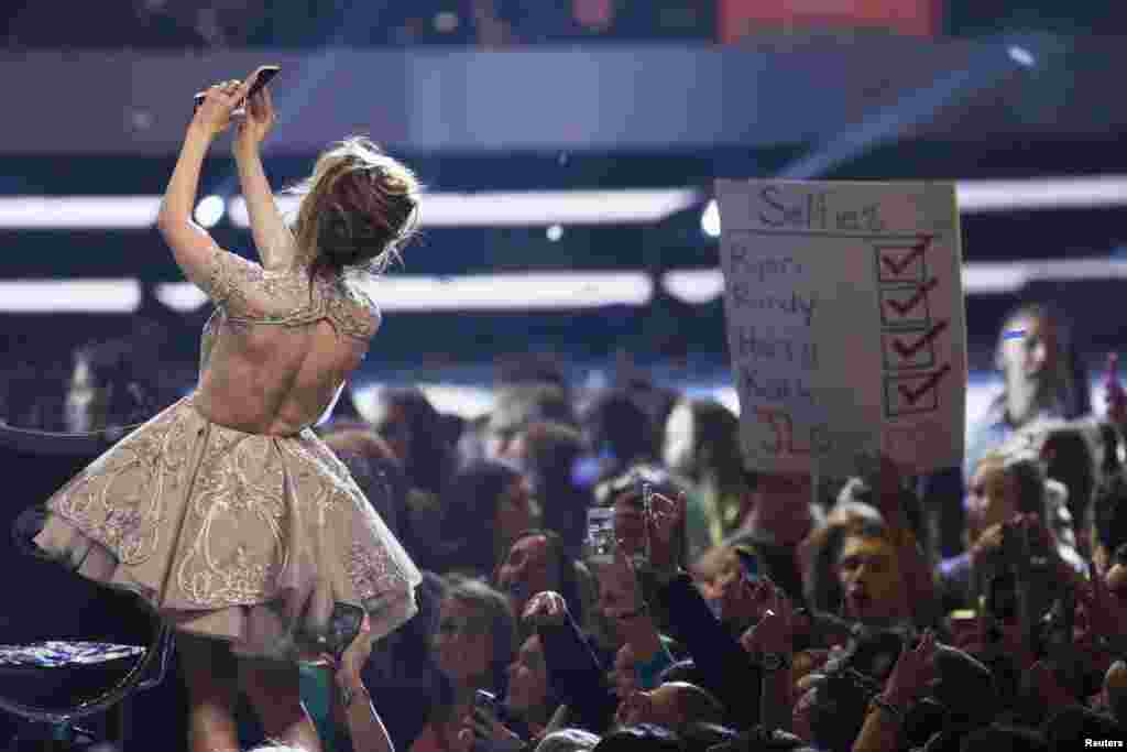 Judge Jennifer Lopez, an American singer and actress, takes a "selfie" during the American Idol XIII 2014 Finale in Los Angeles, California, May 21, 2014.