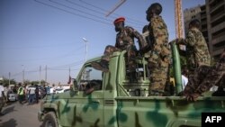 
Des militaires soudanais dans une camionnette face aux manifestants rassemblés devant le siège de l'armée à Khartoum, la capitale, le 27 avril 2019.

