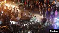 People are seen gathered at the site of a car bomb blast in Azaz, Syria, June 2, 2019.