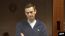 Alexei Navalny, accusé d'avoir diffamé un ancien combattant de la Seconde Guerre mondiale, debout dans une cellule de verre lors d'une audience au tribunal à Moscou. 