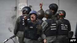 Members of the Bolivarian National Guard clash with protesters near Cotiza Bolivarian National Guard headquarter in Caracas, Venezuela, Jan. 21, 2018.