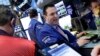 Specialist James Sciulli, center, works with traders at his post on the floor of the New York Stock Exchange, Feb. 22, 2016. Stocks are jumping Monday as the price of oil surges, lifting energy stocks. 