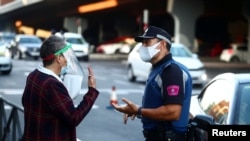 A local police officer speaks with a woman in the Vallecas neighborhood during the first day of a partial lockdown between and within areas in six districts amid the outbreak of the coronavirus disease (COVID-19) in Madrid, Spain, Sept. 21, 2020.