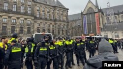 Pro-Palestinian protesters face Dutch police while taking part in a banned demonstration in Amsterdam, Nov. 10, 2024. 