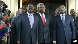 Kenya's Prime Minister Raila Odinga, left, Sierra Leone's President Ernest Bai Koroma, center, and Ivory Coast President Laurent Gbagbo, right, pose for photographers at the presidential palace in Abidjan, Jan 3, 2011