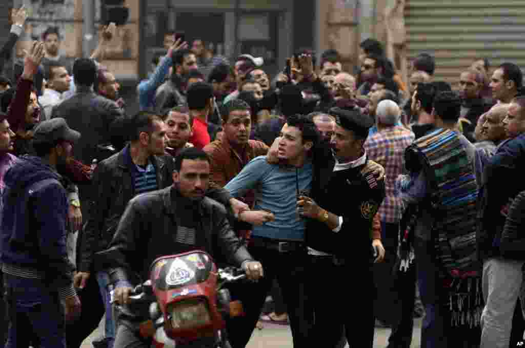 A supporter of Egypt's ousted President Mohamed Morsi is detained by police during clashes with security forces in downtown Cairo, Egypt.
