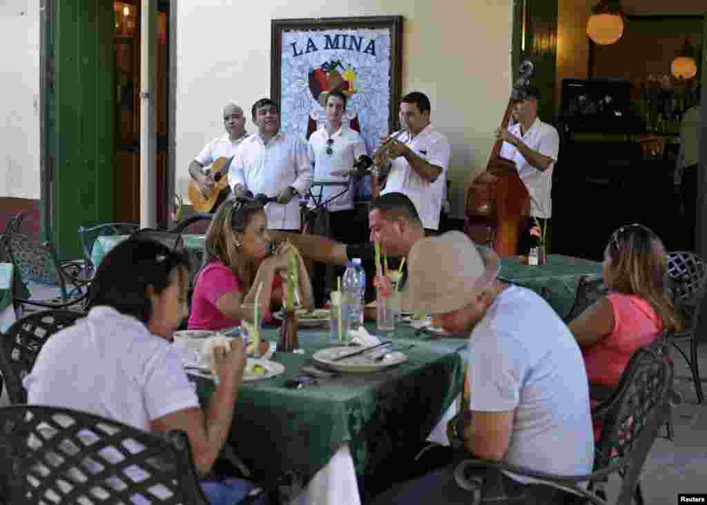 Para musisi tampil menghibur turis di restoran "La Mina" di Old Havana, Kuba (18/12).(Reuters/Enrique De La Osa)