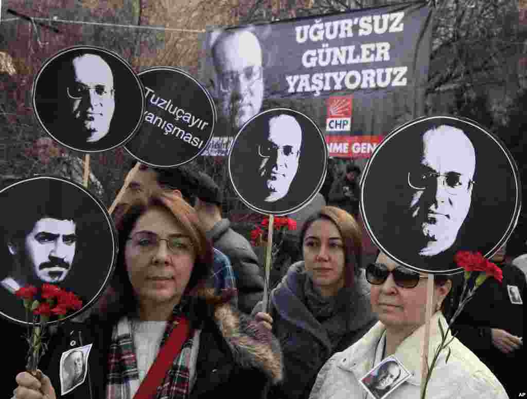 "Sejumlah perempuan memegang poster Ugur Mumcu, wartawan investigatif Turki yang paling terkenal yang dibunuh pada tahun 1993, dan juga poster Ali Ismail Korkmaz, seorang mahasiswa Turki yang tewas dalam sebuah protes pada musim panas tahun lalu. Sementra itu, ribuan orang lainnya yang berkumpul untuk memperingati perayaan ulang tahun meninggalnya Mumcu di Ankara. Tulisan pada poster di latar belakang berbunyi: 'Kami hidup tanpa Ugur (yang juga berarti keberuntungan).'