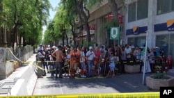 People are prevented to enter a security area after an explosion in Tunis, Thursday June 27, 2019. 