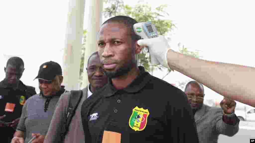 Le joueur de football malien Seydou Keita, la température en train de parler au cours des tests du virus Ebola à l'arrivée à l'aéroport international de Malabo à Malabo, Guinée équatoriale vendredi 16 janvier 2015.
