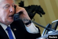 U.S. President Donald Trump speaks by phone with Russia's President Vladimir Putin in the Oval Office at the White House in Washington, Jan. 28, 2017.