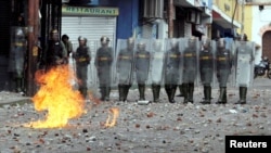 Security forces look on while clashing with opposition supporters participating in a rally against Venezuelan President Nicolas Maduro's government and to commemorate the 61st anniversary of the end of the dictatorship of Marcos Perez Jimenez in Tachira, 