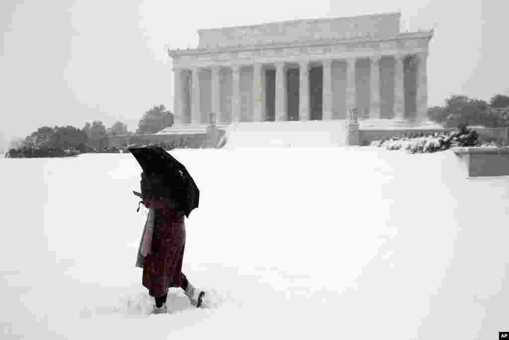 Un femme marche dans la neige devant le Lincoln Memorial à Washington DC, le 23 janvier 2016.(AP Photo/Alex Brandon)