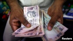 A private money trader counts Indian rupee currency notes at a shop in Mumbai, India, Aug. 1, 2013. 