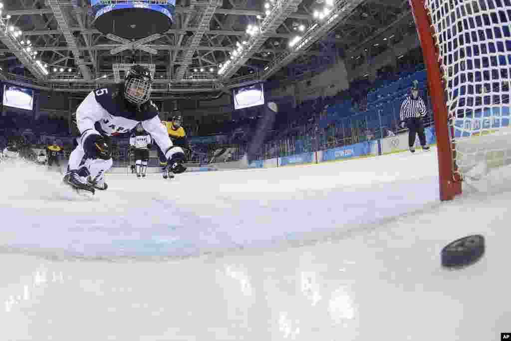 Kanae Aoki dari Jepang mengejar bola setelah gol dicetak Franziska Busch dari Jerman pada detik-detik terakhir pertandingan hoki es antar kedua negara pada Olimpiade Musim Dingin, Sochi, 13 Februari 2014.