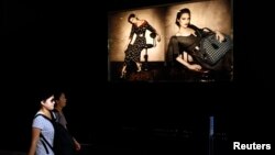 Shoppers walk past a Prada store at Hong Kong's shopping Tsim Sha Tsui district, Sept. 16, 2013.